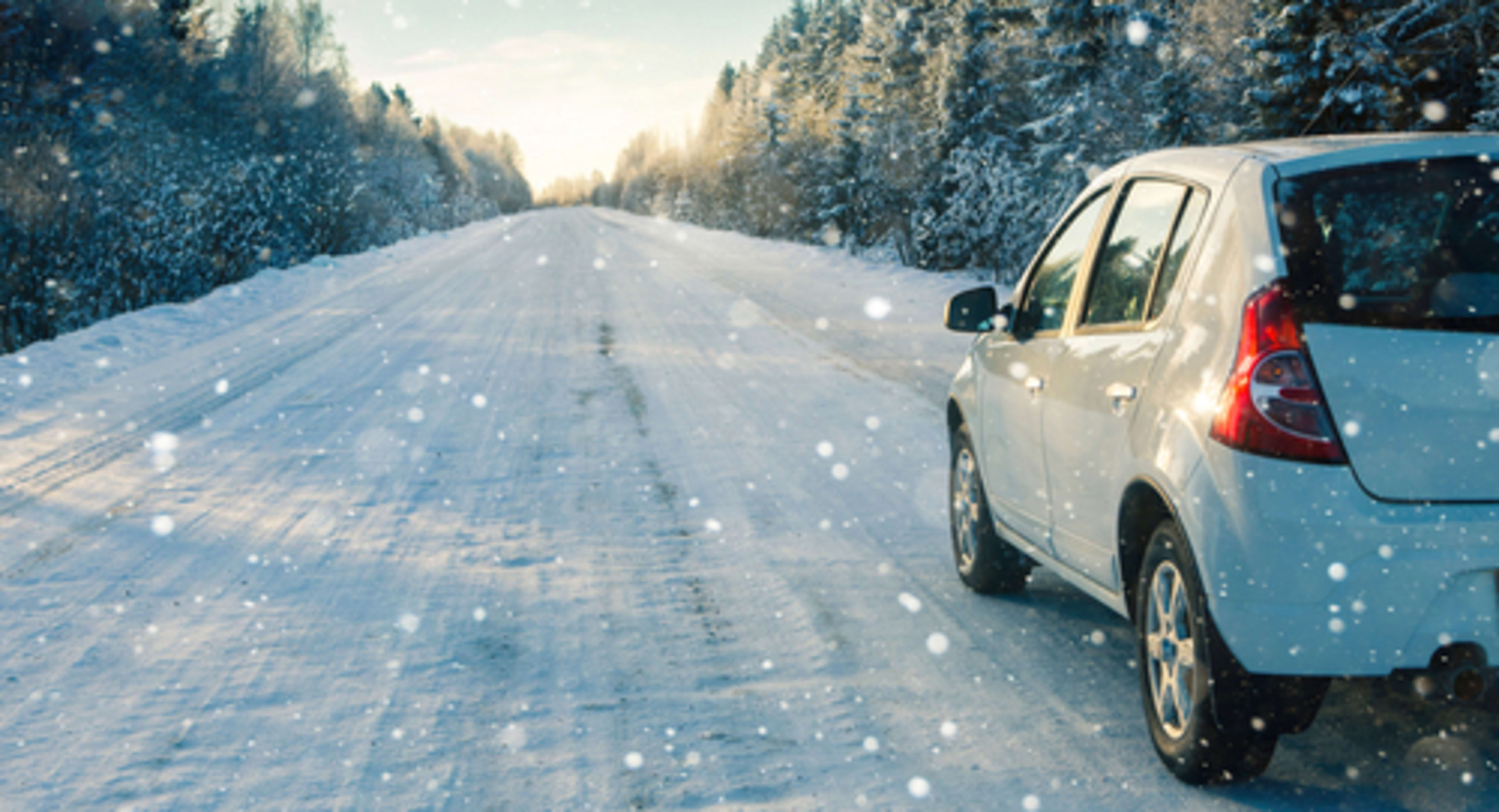 CUV on a winter road driving through snow with winter tires.