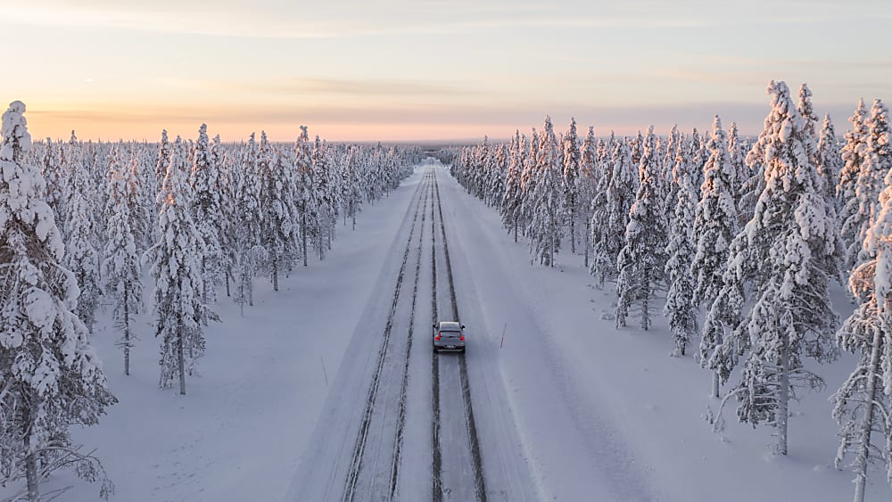 Nokian Hakkapeliitta 10 tires on a passenger car driving away on a snowy day.