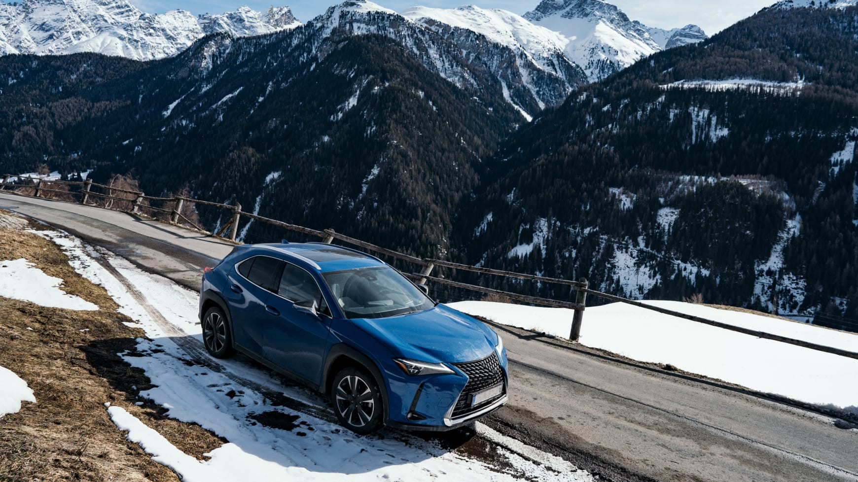 A Crossover Vehicle Driving Through Mixed Weather Conditions in the Mountains