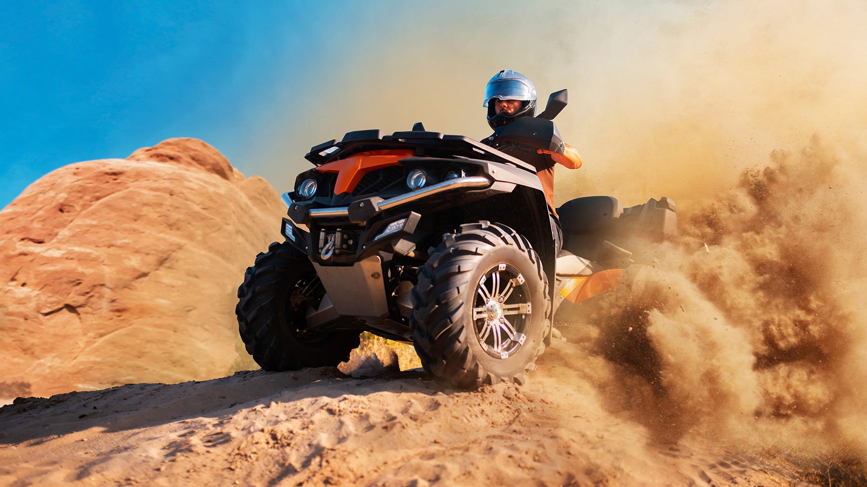 Quad Bike Equipped with Sand Tires Driving Through Sandy Dune Background