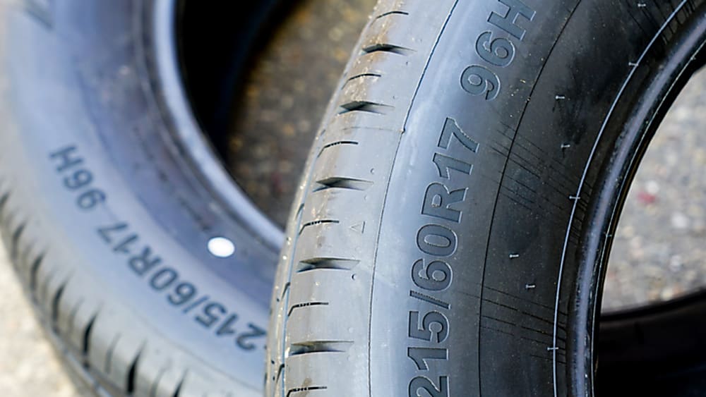A tire's sidewall showing tire size, load index, and speed rating.